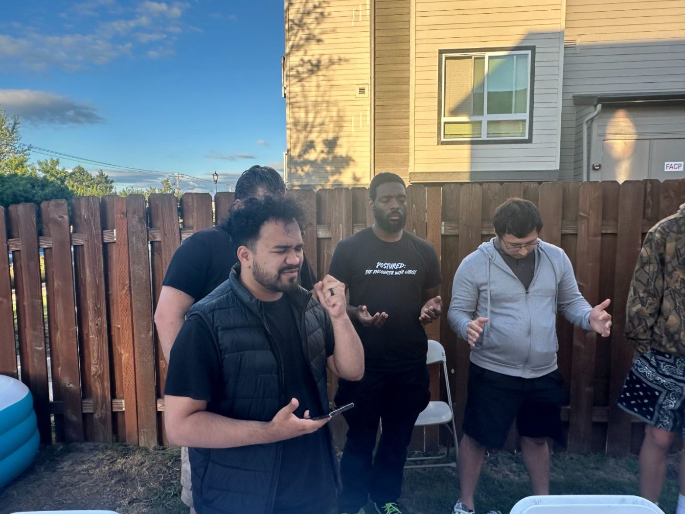 Two men talking on the patio while others sit at the table