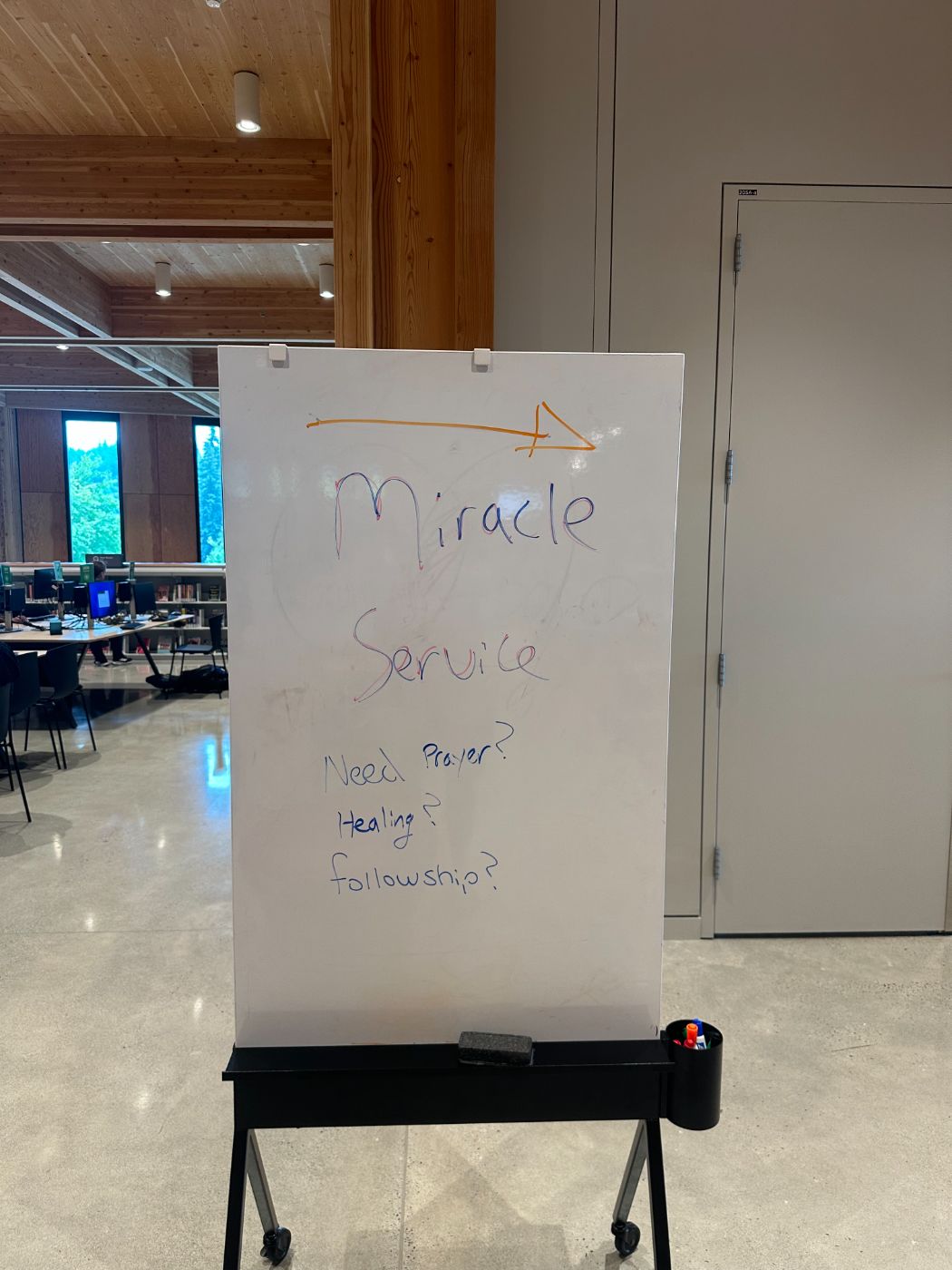 Whiteboard sign reading Miracle Service: need prayer, healing, fellowship